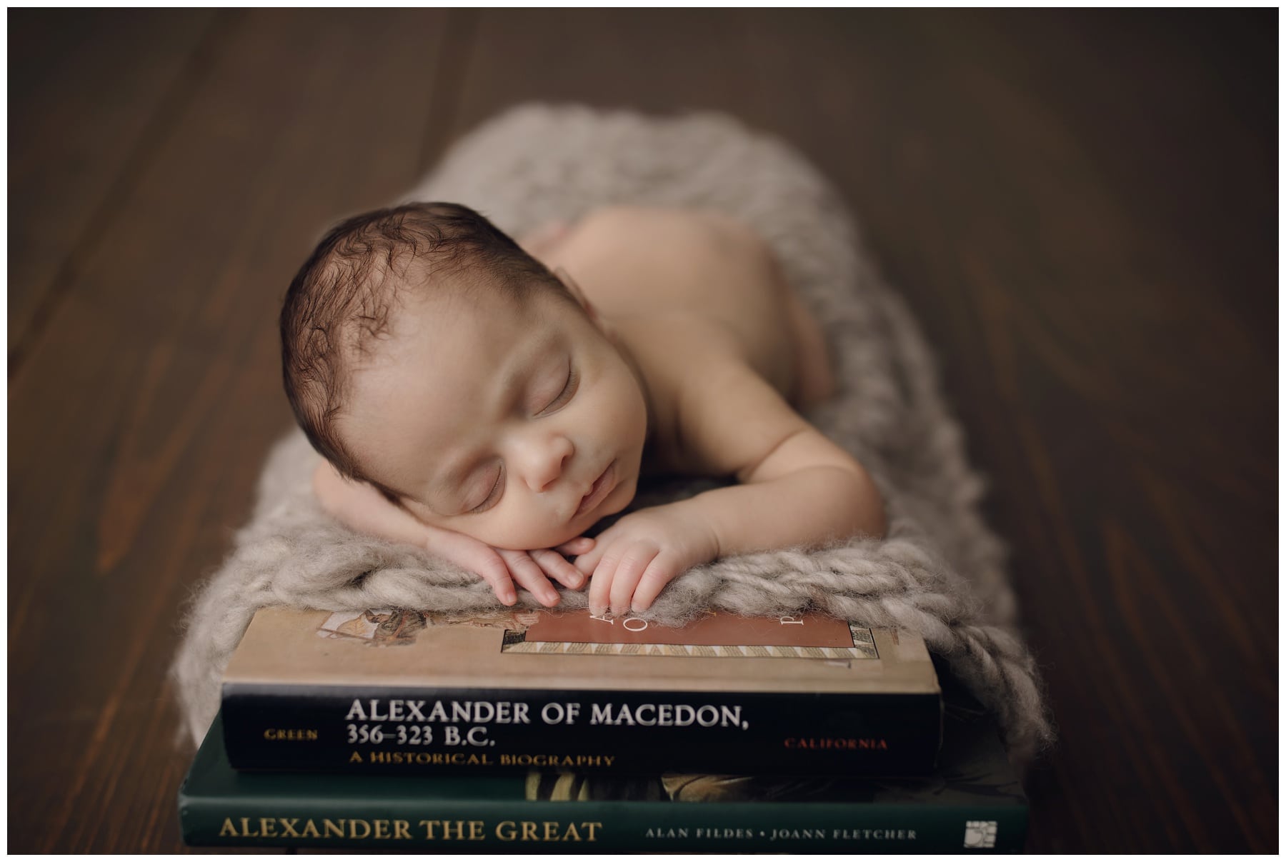 Newborn baby boy sleeping on top of books during photo session with 8.08 Photography in Jacksonville Fl