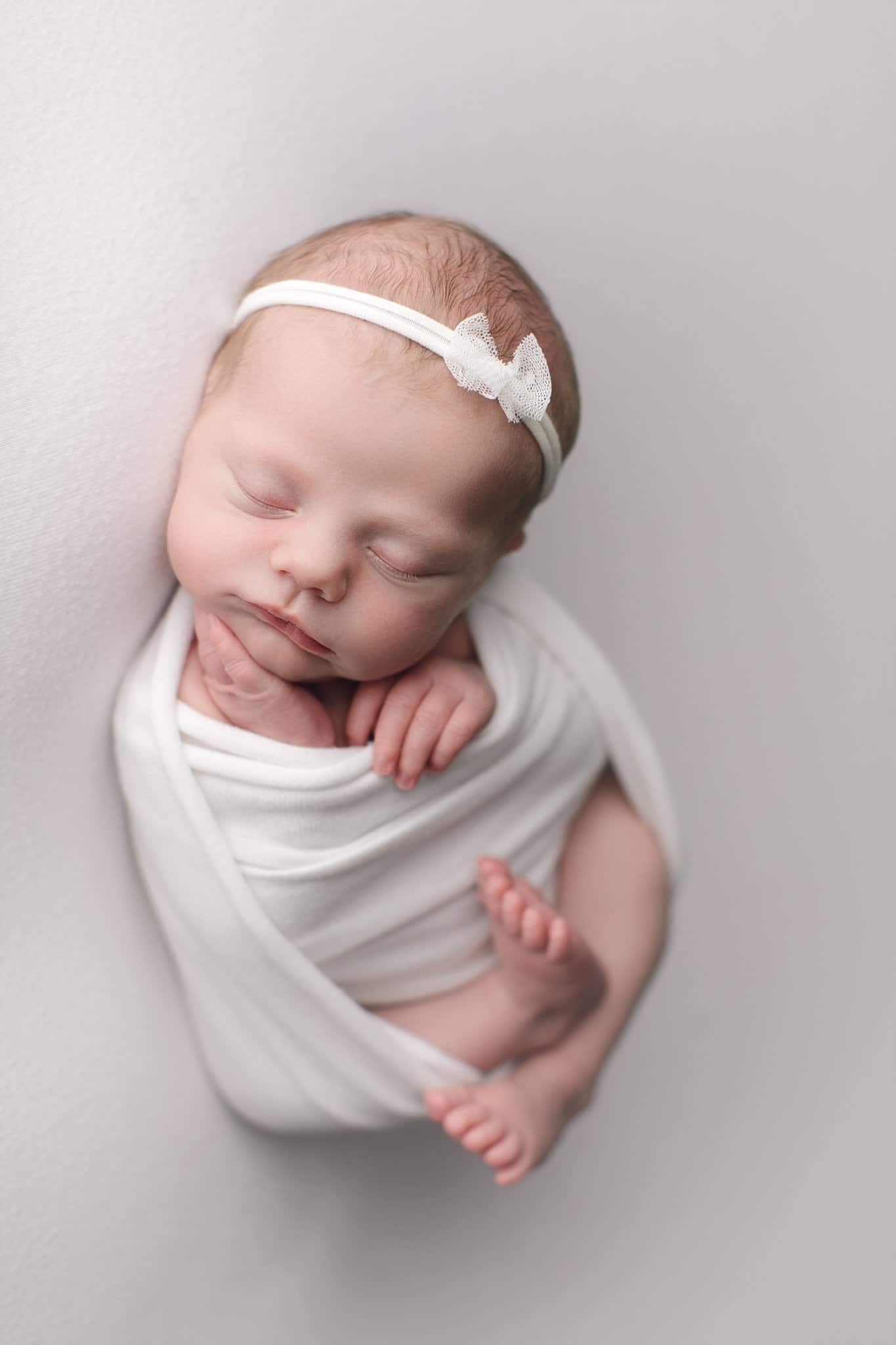 Custom Newborn Portraiture Jacksonville Fl newborn photo session. sleeping baby simple white wrap bow and backdrop