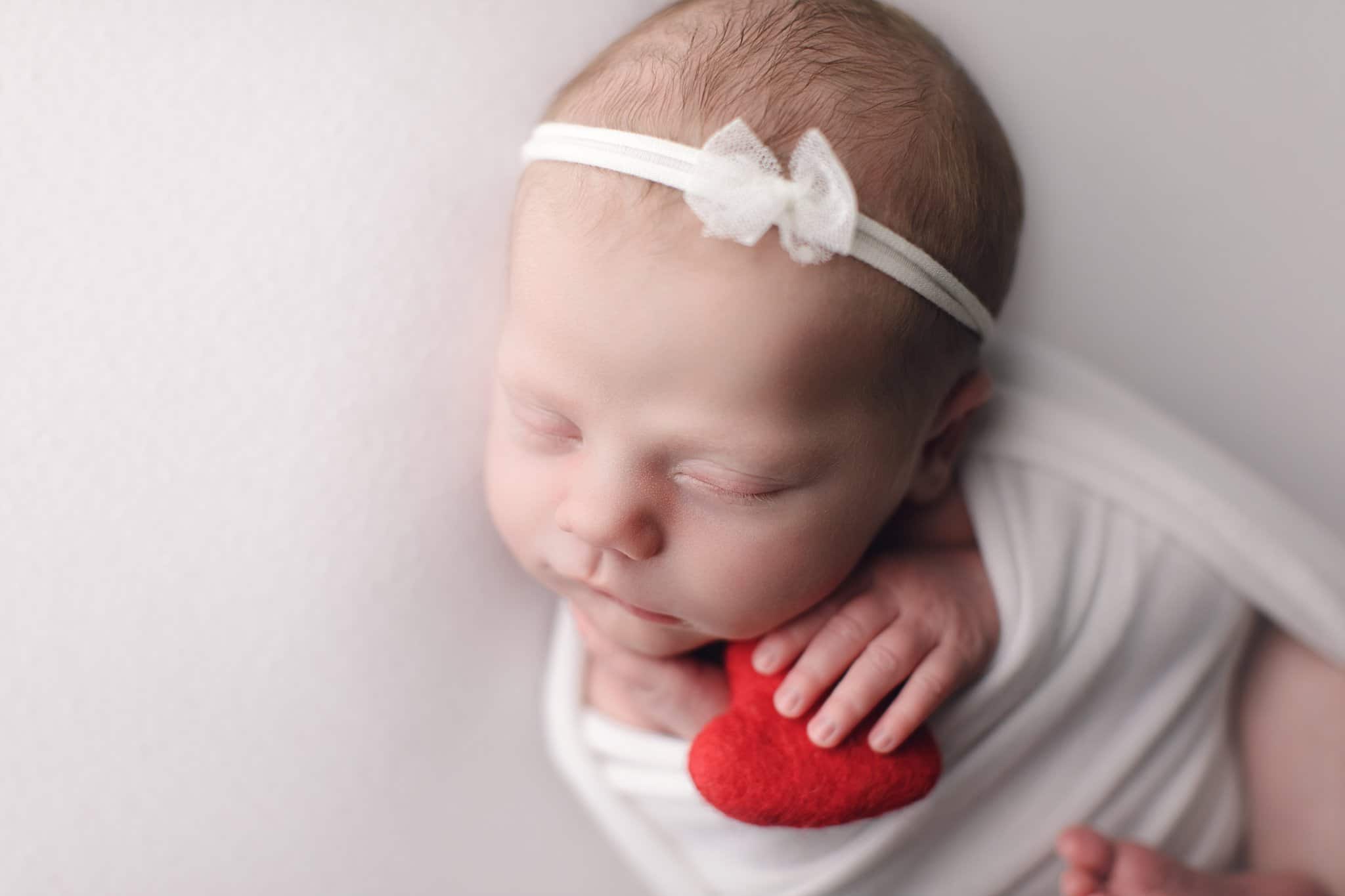 Custom Newborn Portraiture Jacksonville Fl newborn photo session. sleeping baby simple white wrap bow and backdrop red heart
