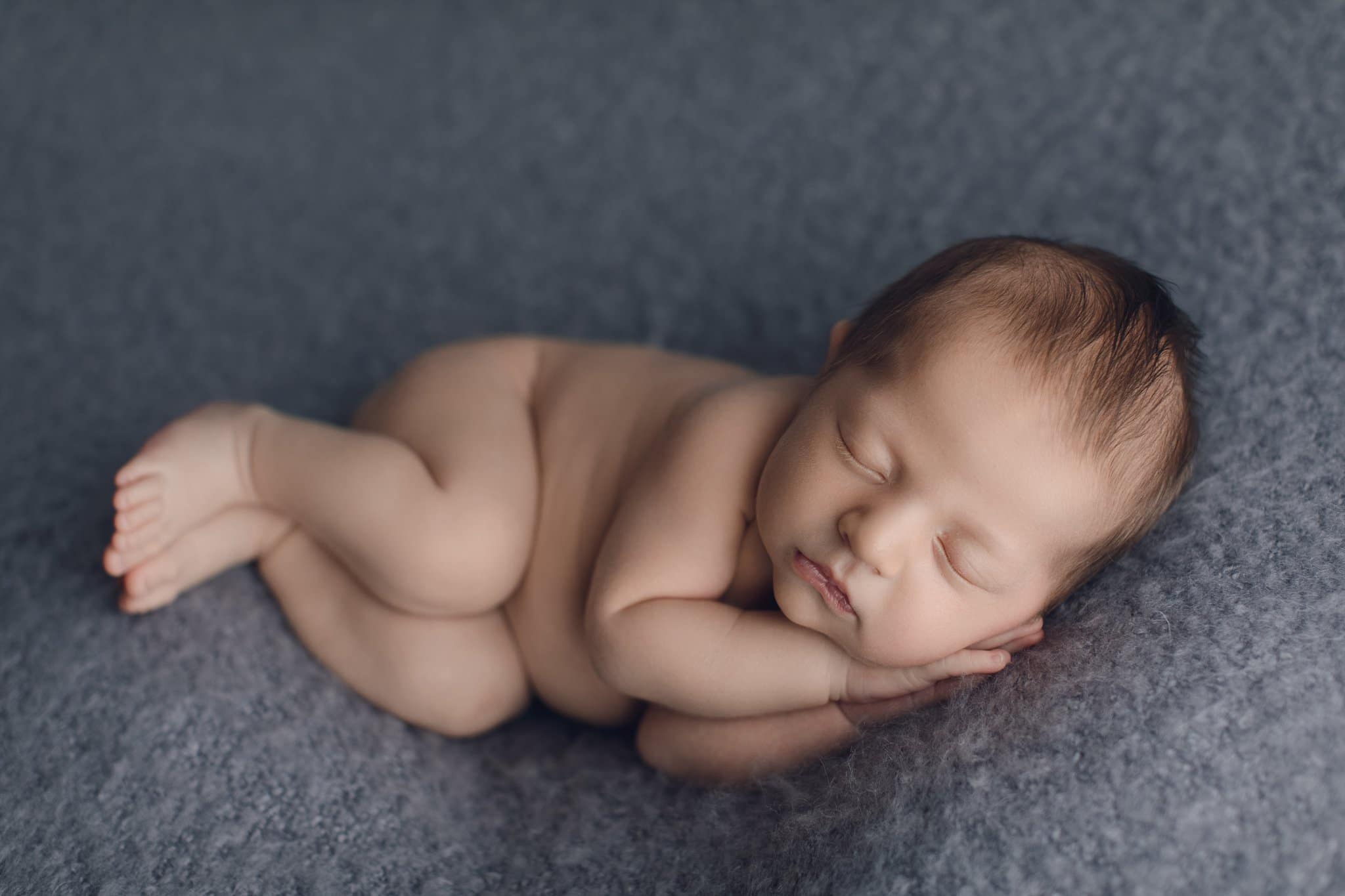 newborn baby boy sleepy on dusty blue blanket