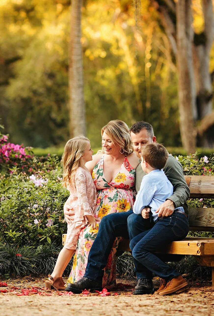 St Augustine Maternity Photographer Washington Oaks Gardens State Park family of 4 on garden bench surrounded by beautiful light and flowers