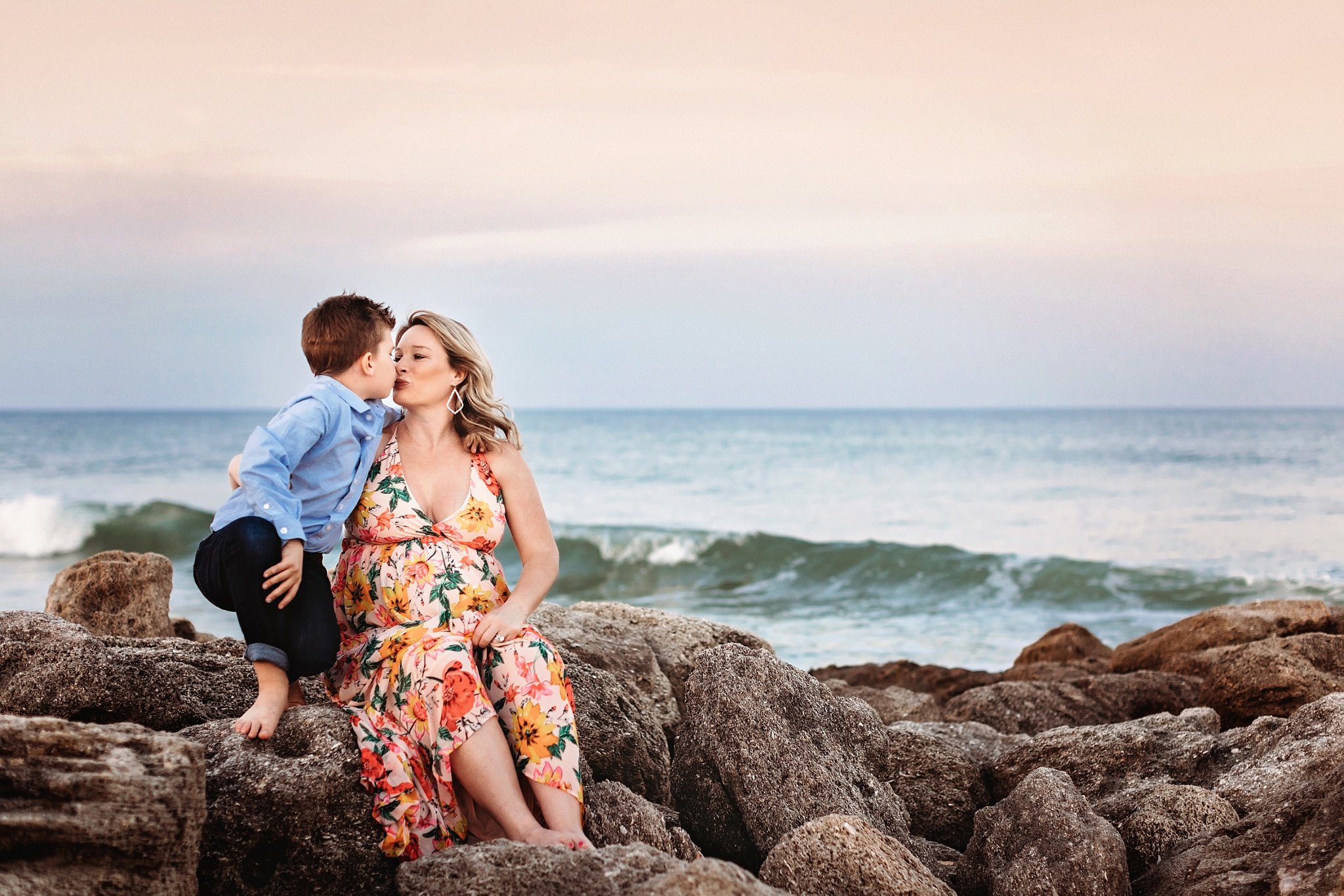 St Augustine Maternity Photographer Washington Oaks Gardens State Park son kissing pregnant mom on rocky beach