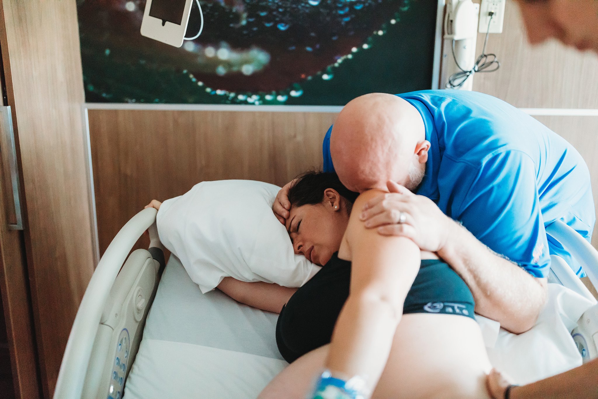 natural Birth Photography Dad supporting laboring mom in hospital delivery room