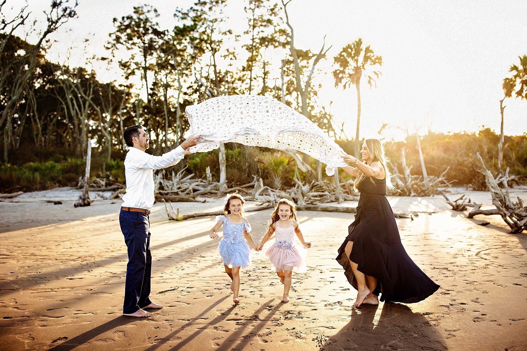 family playing games together during photo session at the beach