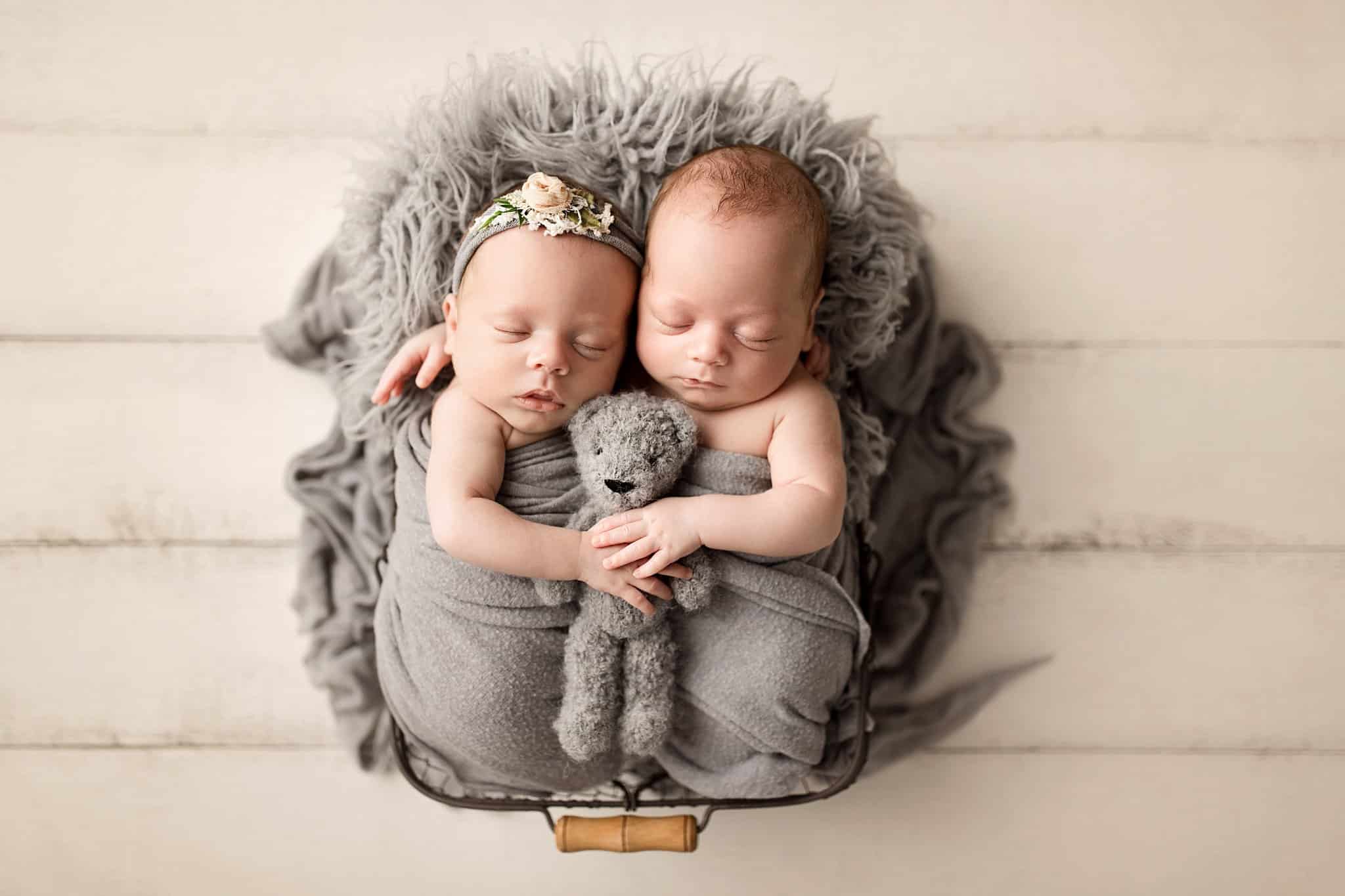 boy girl twins snuggling together holding teddy bear