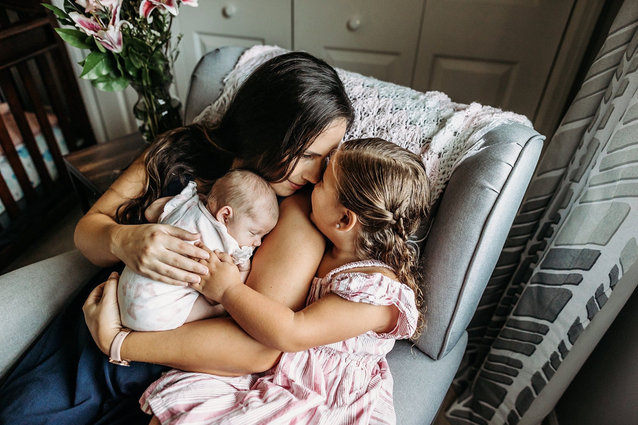 young mom snuggling with her two daughters