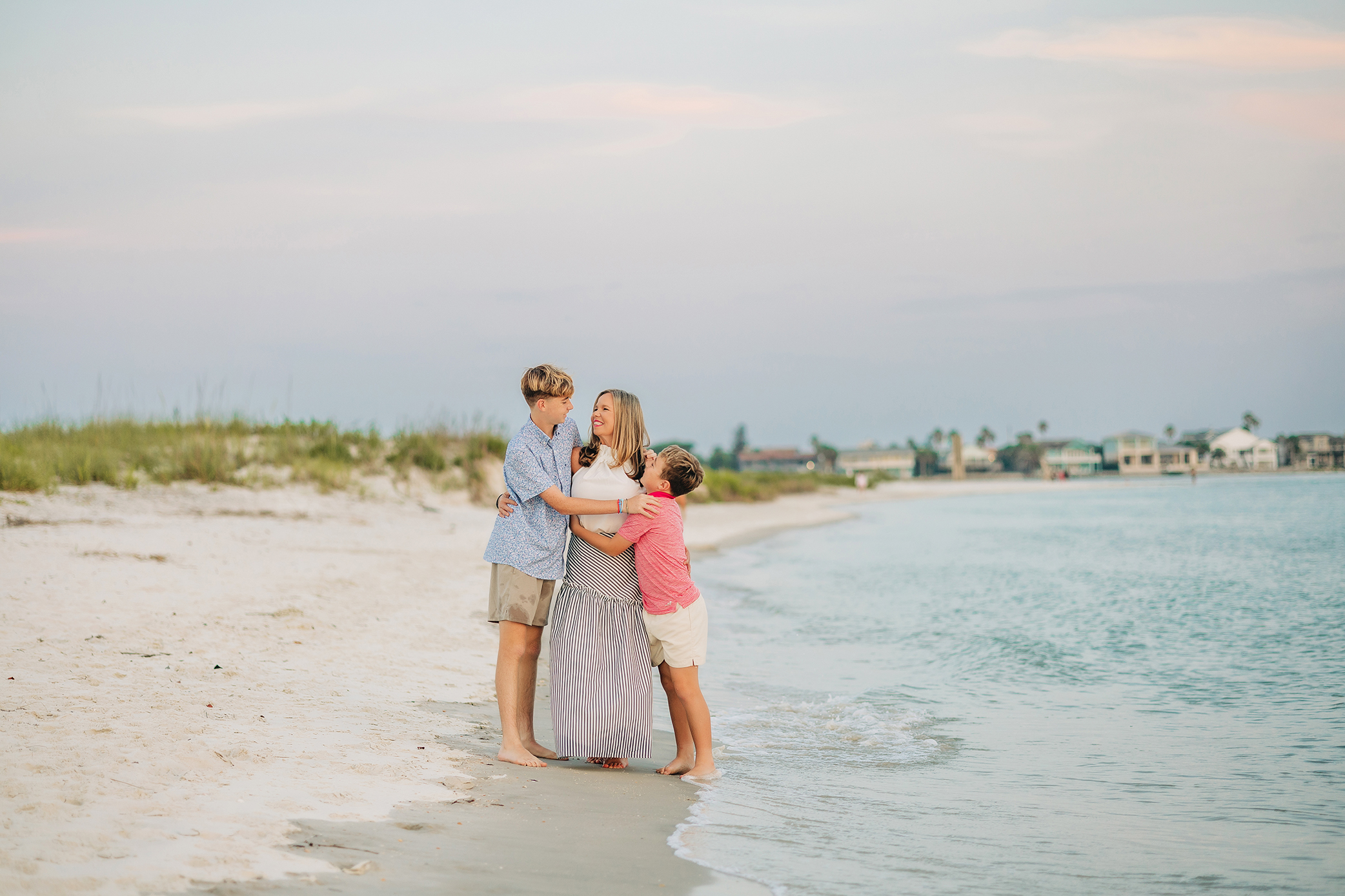Mother hugging her two sons together on the beach in St. Augustine, Florida