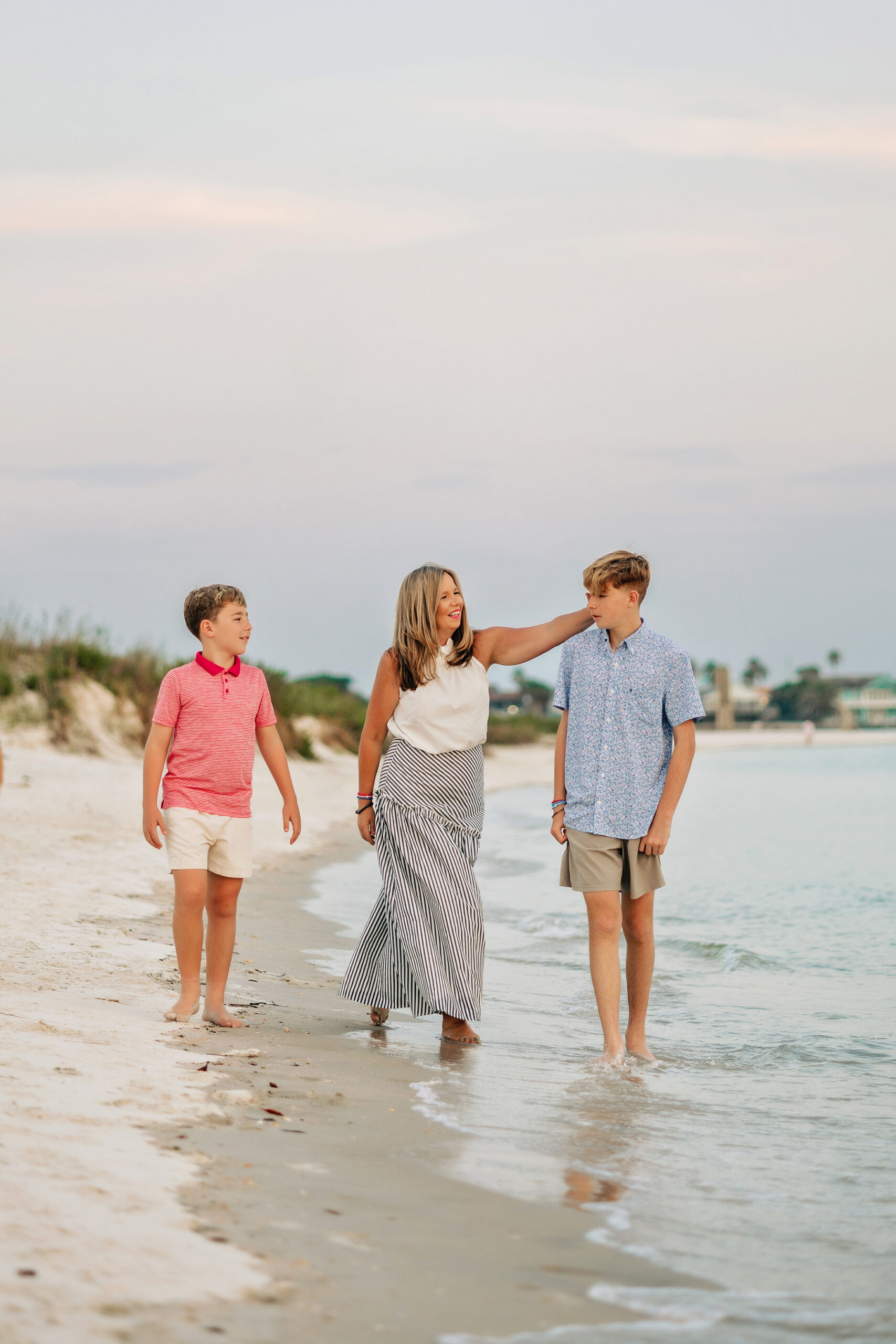 Mother walking along the shoreline with her two sons during a St. Augustine Beach family session